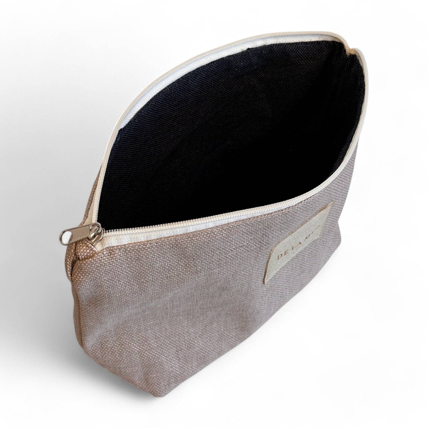 Interno dell’astuccio beige foderato in tessuto grigio spesso, ideale per cosmetici e piccoli oggetti personali.