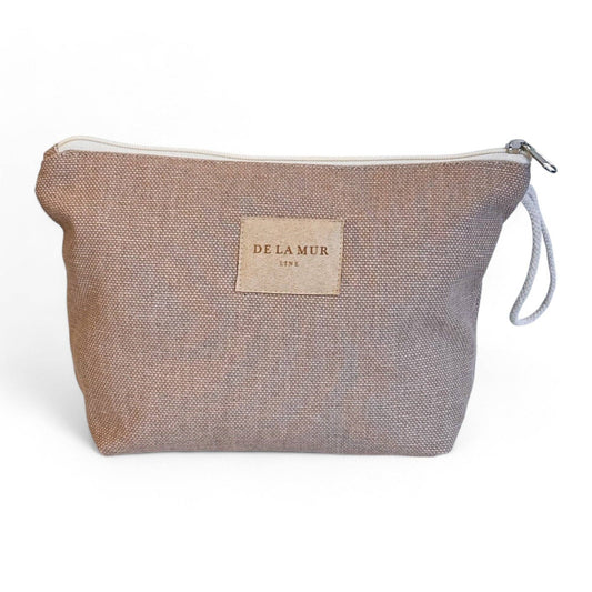 Astuccio beige in tessuto spesso sostenibile con manico in corda grezza e cerniera superiore.