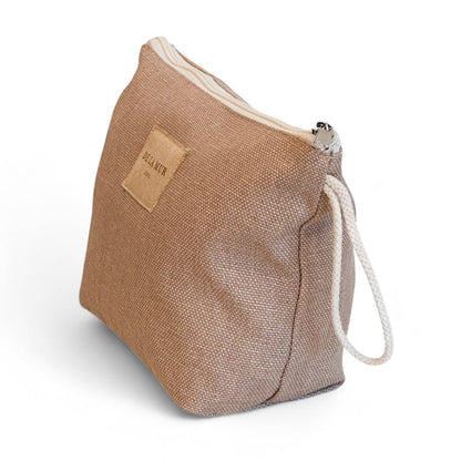 Vista laterale dell’astuccio beige in tessuto spesso con manico in corda color grezzo e chiusura a zip.