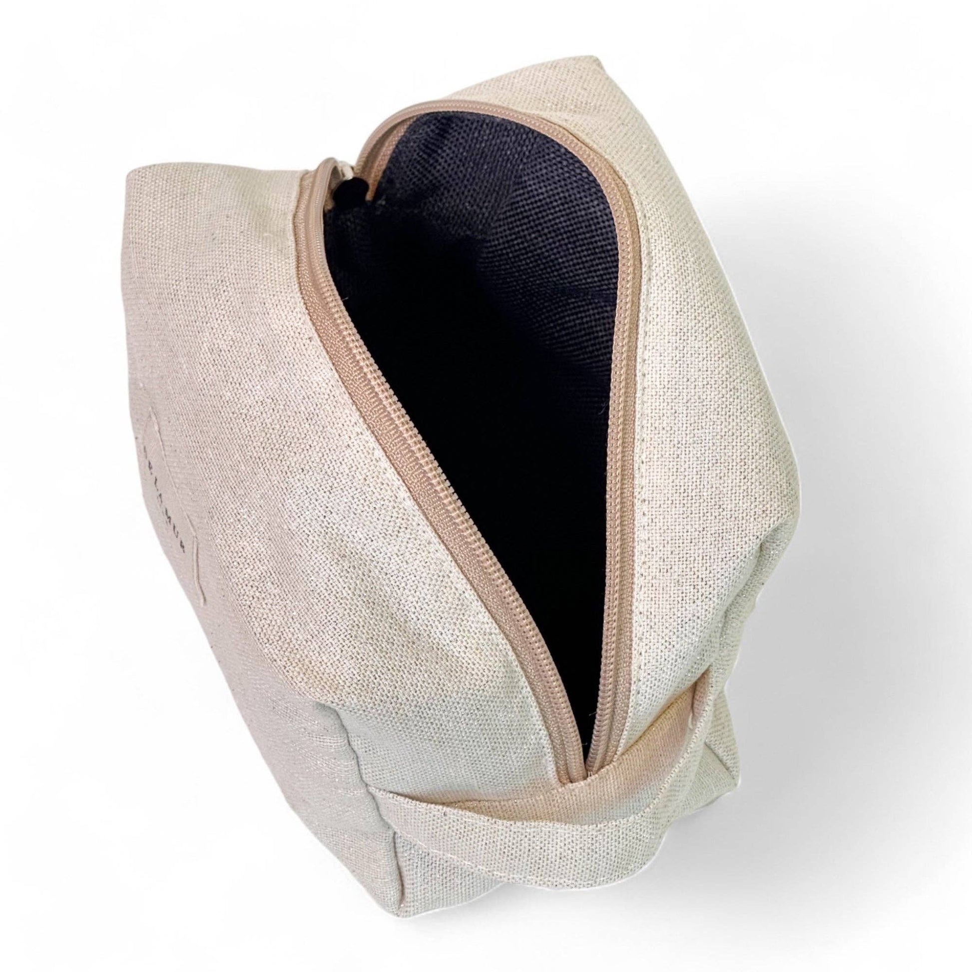 Interno del beauty case beige in tessuto fine half-panama con lurex, ideale per cosmetici e creme viso.