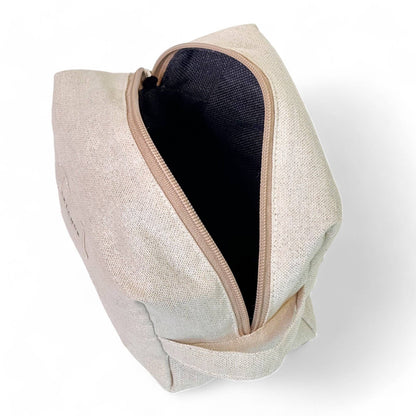 Interno del beauty case beige in tessuto fine half-panama con lurex, ideale per cosmetici e creme viso.