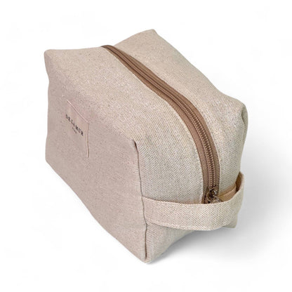Vista laterale del beauty case beige in tessuto naturale con lurex, elegante porta trucchi da viaggio.