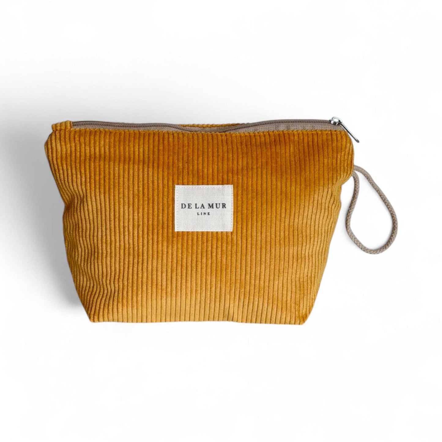 Beauty case in velluto a coste color senape con manico in corda beige e cerniera superiore.