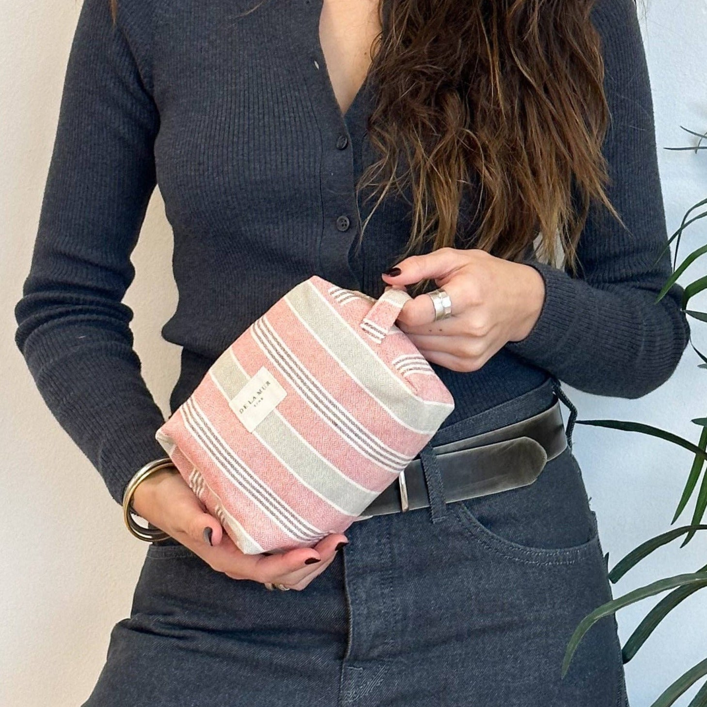 ragazza che tiene un beauty bag a righe