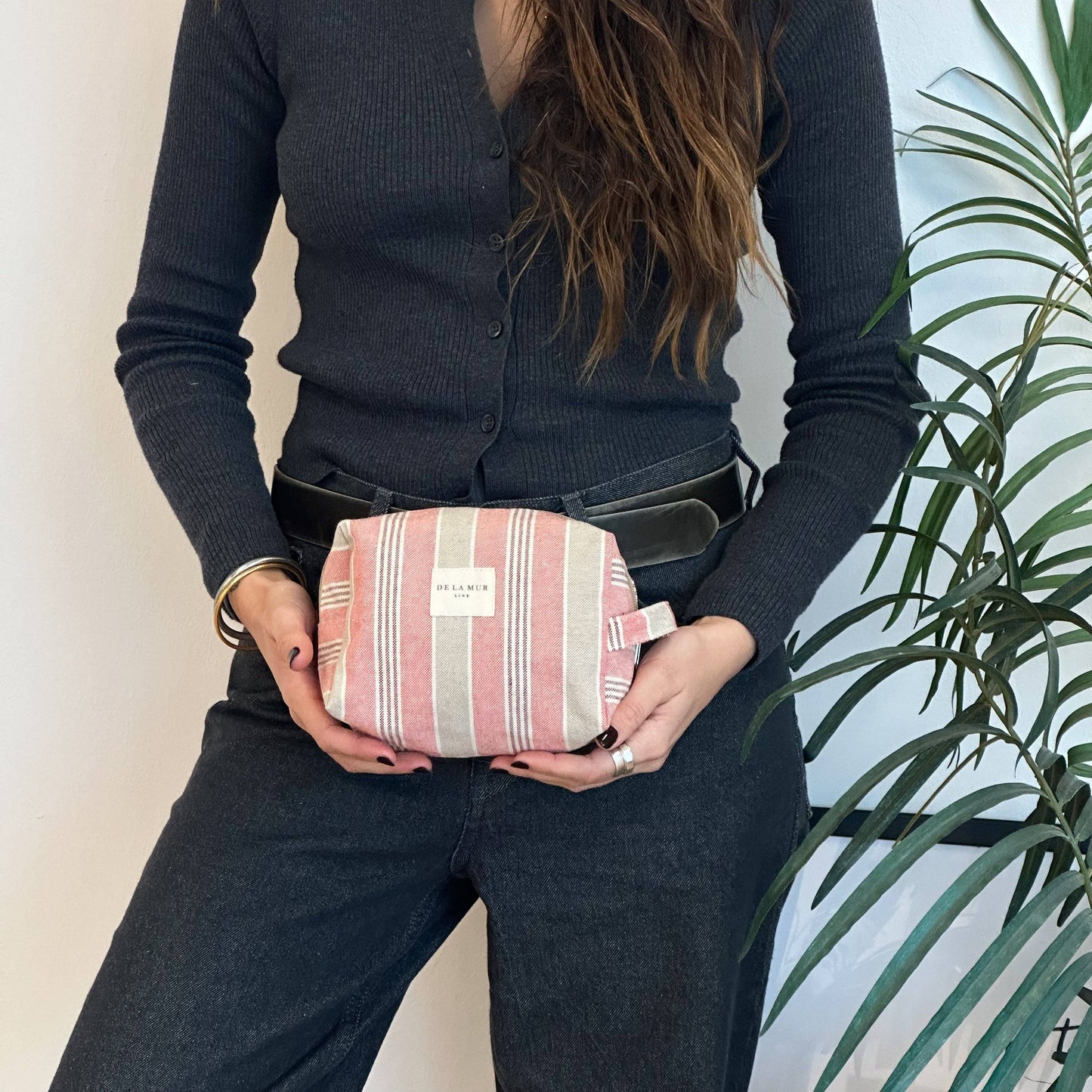 ragazza che tiene borsa da toilette a righe