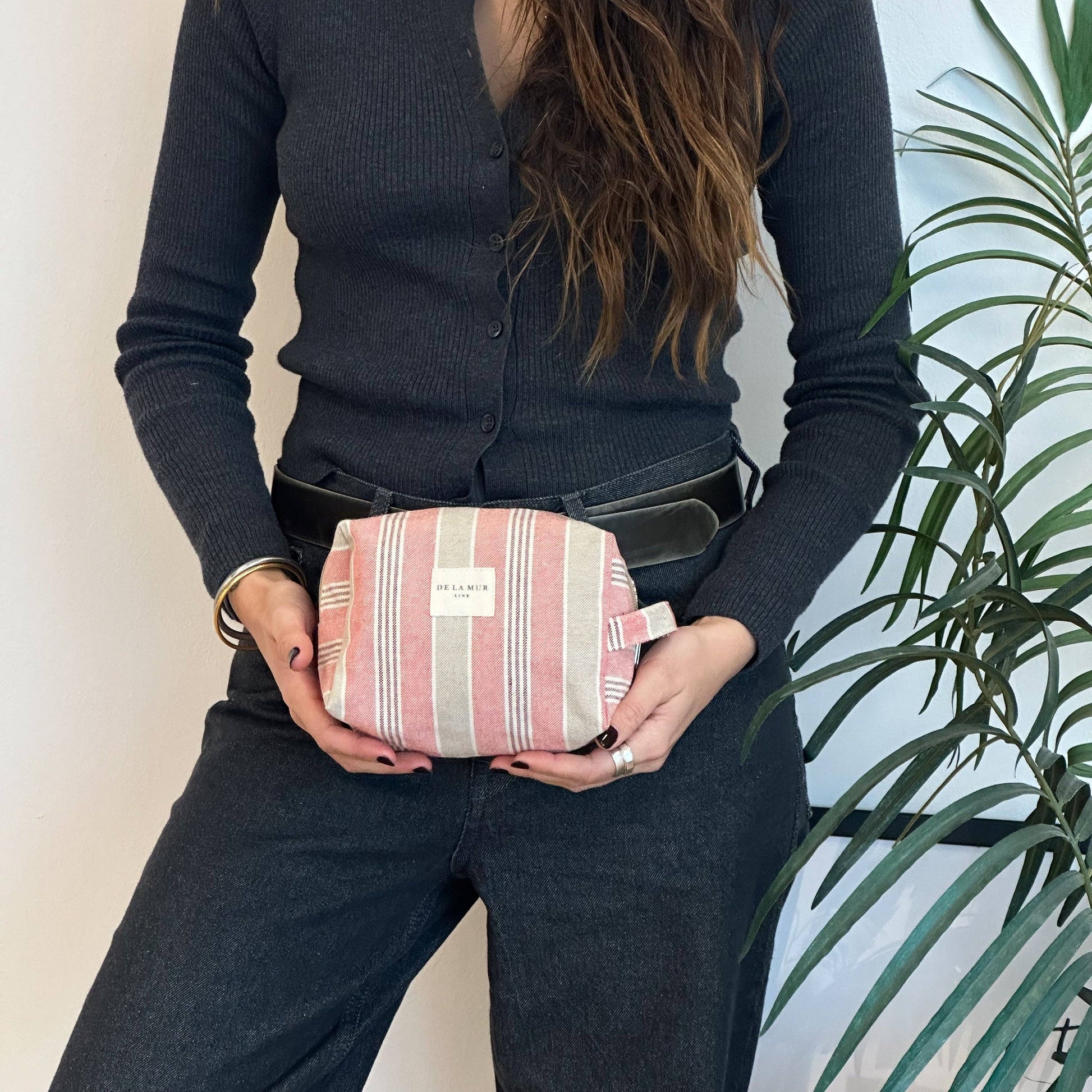ragazza che tiene borsa da toilette a righe