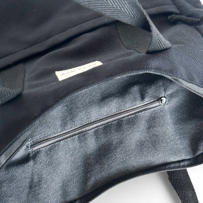 Interno dello zaino in velluto nero con tasca e cerniera.