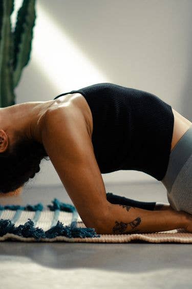 dettaglio del tappeto yoga con una donna in posizione yoga